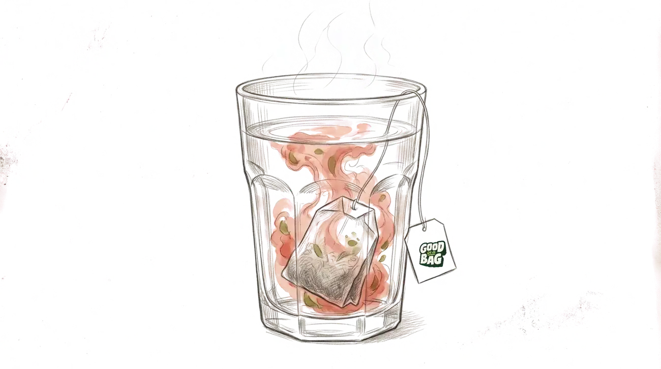 A tea bag steeping in a glass of hot water